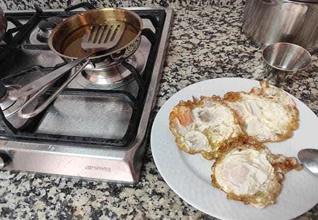 Huevo frito con puntilla cocinándose en la sartén pequeña Fissler, una de las sartenes para huevos más recomendadas.