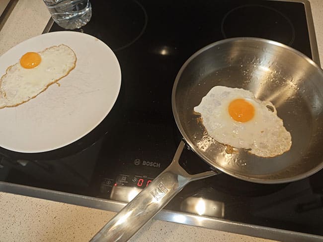 Huevos fritos a alta temperatura en una sartén de acero sin recubrimiento.