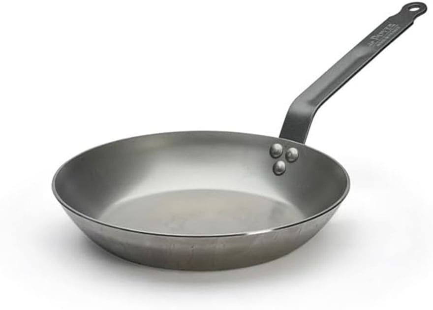 Sartén profesional De Buyer Carbone Plus de hierro pesado utilizada en cocinas de restaurantes.