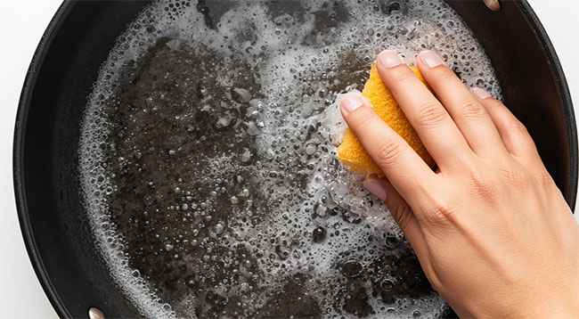 Foto de una sarten quemada por dentro reaccionando con espuma de bicarbonato y vinagre.
